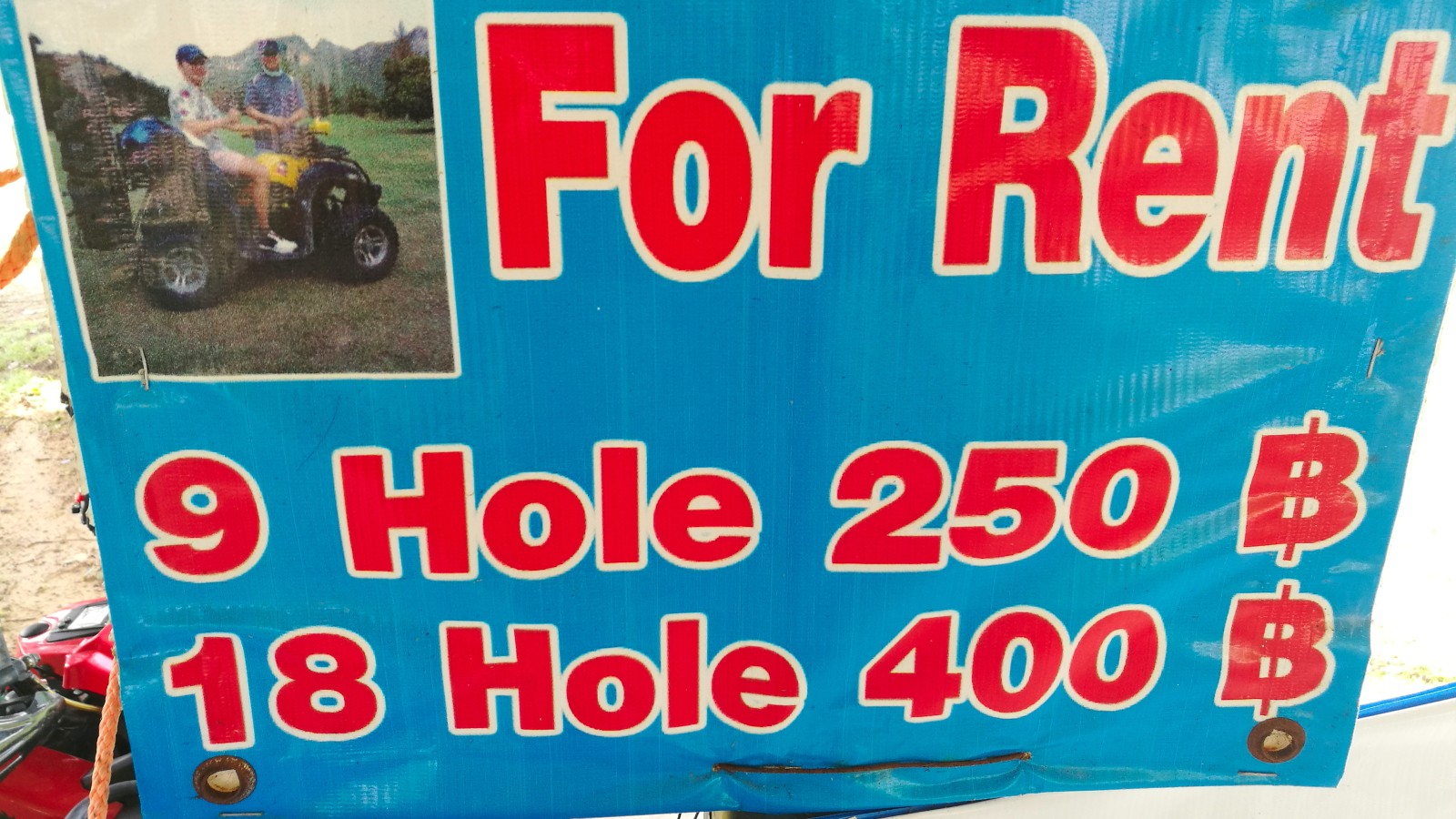 sign describing the ATV rental prices at a golf course in Thailand